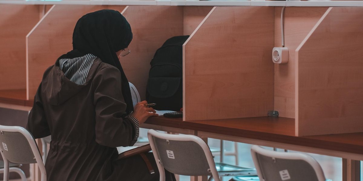 A student working diligently in a library or classroom setting, representing academic integrity.