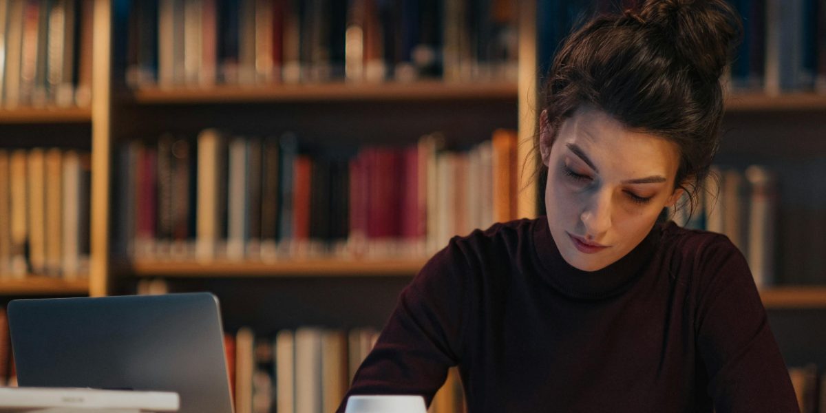 A student focusing on their studies in a public or casual setting, reflecting the need for free resources.