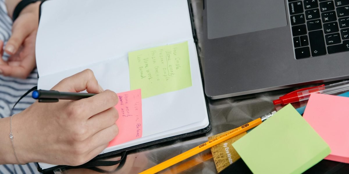 A person intently writing notes on paper, symbolizing human originality in content creation.