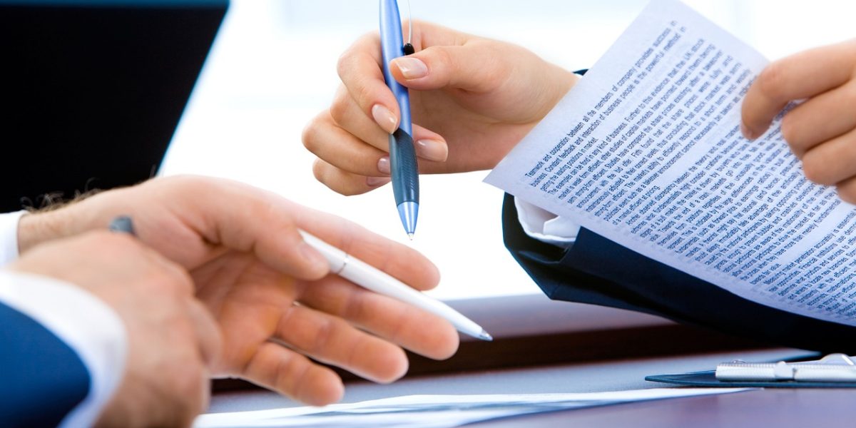 Colleagues discussing a document during a meeting, representing the human review process for flagged content.