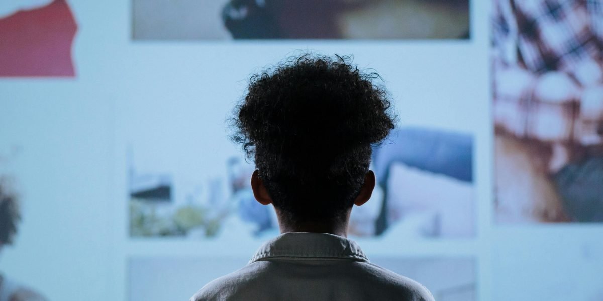 A person thoughtfully examining digital artwork, contemplating its origin and authenticity.