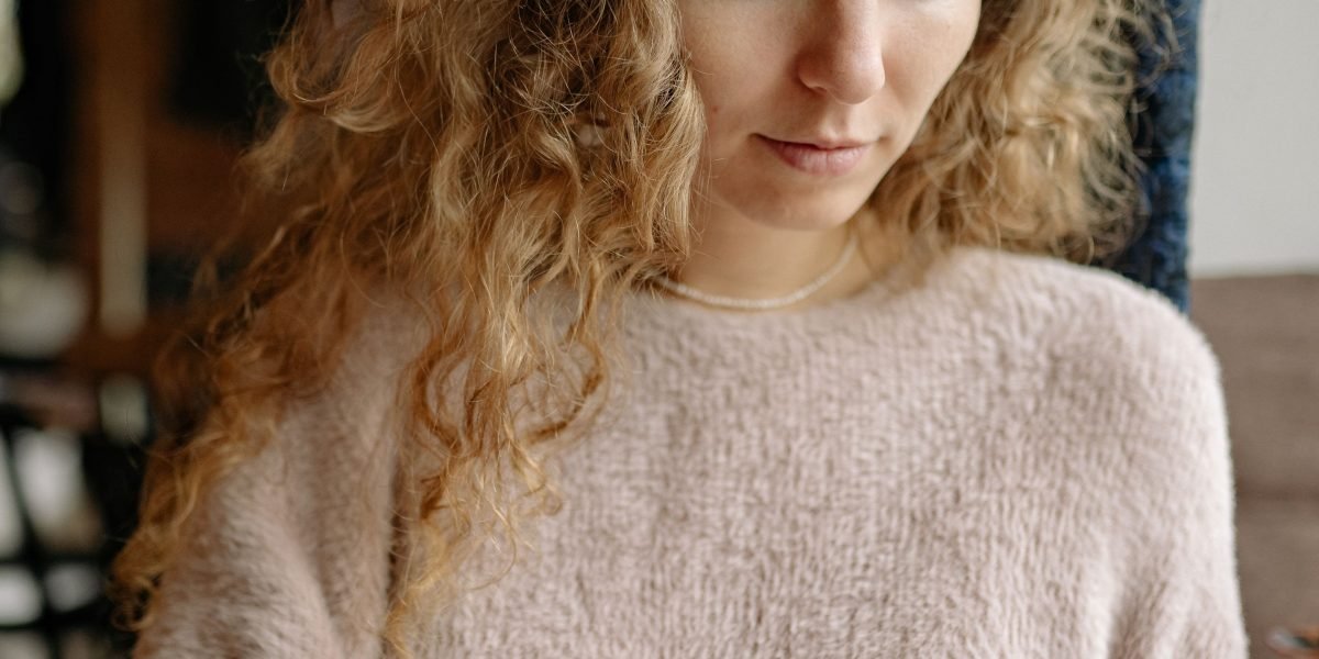 A person exhibiting signs of stress while interacting with a smartphone, reflecting the mental health impact of social media algorithms.