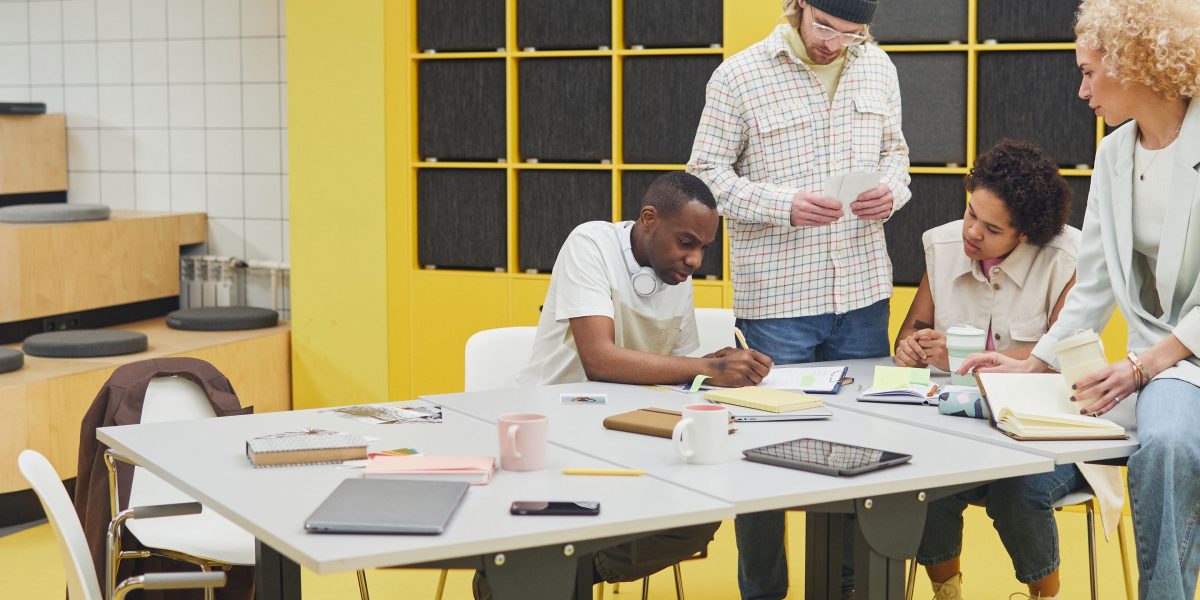 A diverse team engages in a collaborative discussion, emphasizing the crucial role of human expertise and oversight in guiding AI projects to success.