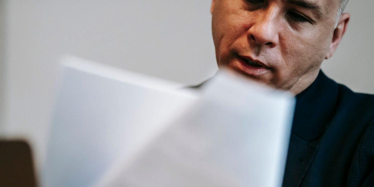 A person carefully reviewing documents, emphasizing the need for human judgment in conjunction with AI detection tools.